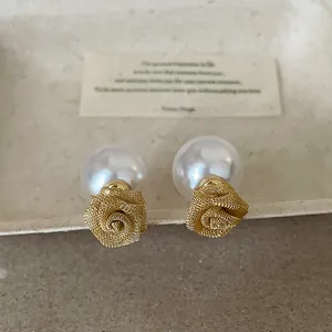 Gros plan de boucles d'oreilles rose en maille dorée avec fermoir grosse perle