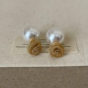 Vue détaillée des boucles d'oreilles double face avec rose en maille et perle, look chic