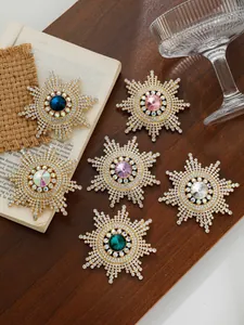 Detailansicht von sechs Sonnenblumen-Brosche mit bunten Strasssteinen auf Vintage-Grund.