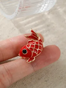 Nahaufnahme einer roten Koi-Fisch-Emaille-Brosche mit detaillierter Handwerkskunst