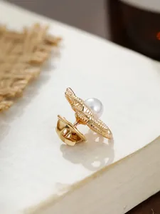 Detailansicht einer goldenen Kamelien-Brosche mit Perle und Schmetterlingsverschluss