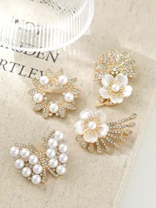 Detailaufnahme eleganter Perlen- und Strassbroschen mit Blumen für modische Accessoires.
