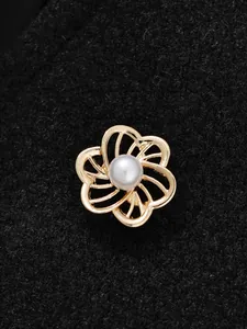 Detailansicht eines eleganten goldenen Kamelien-Blütenknopfs mit einer weißen Perle