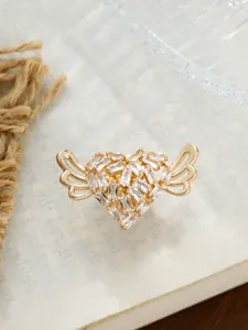 Detaillierte Nahaufnahme einer goldenen Herz-Brosche mit Flügeln und klaren Kristallen