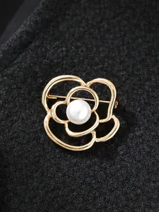 Detailansicht einer eleganten goldfarbenen Kamelien-Brosche mit einer weißen Perle