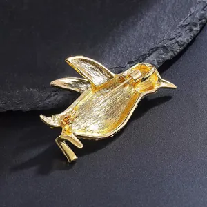 Detailed back view of a golden alloy penguin brooch showing the secure pin mechanism