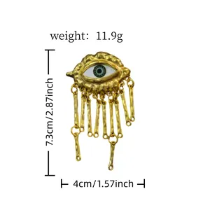 Gold irregular evil eye statement brooch with tassel detail and size indicators