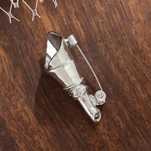 Close-up of silver mini vase brooch for DIY flower arrangement on wood background