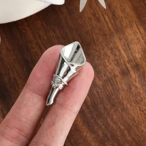 Detail view of a creative silver DIY flower holder brooch pin held to show scale and texture