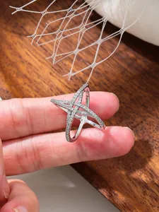 Gros plan d'une boucle de foulard étoile argentée à quatre branches avec pierres