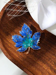 Detailaufnahme der blauen Ahornblatt-Brosche mit funkelnden Strasssteinen
