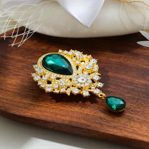 Macro view showing the intricate details of a vintage emerald green teardrop brooch