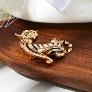 Close-up of a vintage golden tiger brooch with black stripes and green eyes.