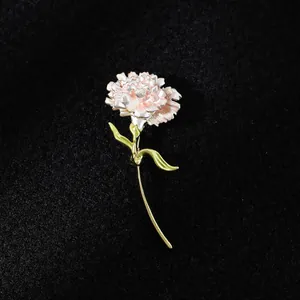 Detailed macro view of an elegant pink carnation flower brooch with a golden stem