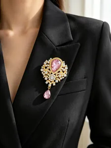 Close-up of a vintage pink water-drop crystal brooch with rhinestones on a black blazer.