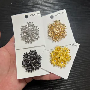 Vue détaillée de quatre broches fleurs vintage avec des strass étincelants colorés