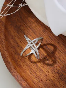 Gros plan d'une boucle de foulard argentée en forme d'étoile avec des strass brillants.