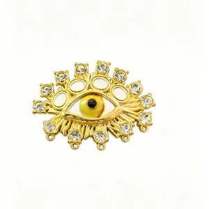 Detailed view of an ornate gold-tone evil eye brooch with clear crystals and enamel