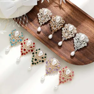 Variété de broches vintage en cristal avec perles de différentes couleurs sur plateau