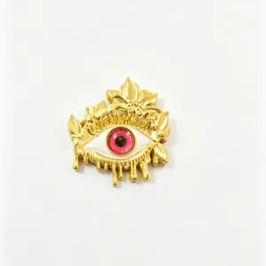 Detailed view of artistic golden melting evil eye brooch with translucent red pupil