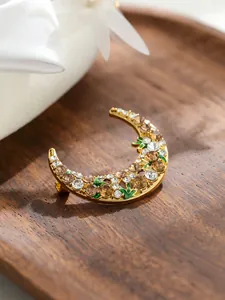 Macro view of exquisite crescent moon brooch with inlaid rhinestones and enamel