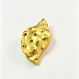 Detailed view of a metallic gold conch shell brooch with unique textured finish