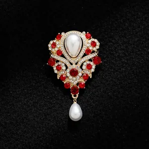 Gros plan de broche en perles vintage français avec strass rouges et finition or