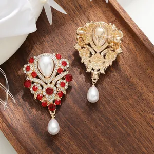 Vue détaillée d'une broche vintage française ornée de strass rouges et perles de nacre