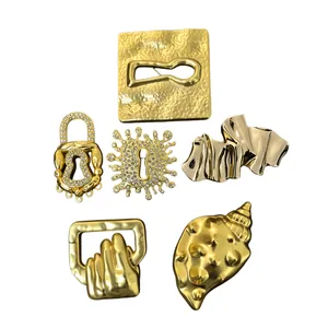 Set of surrealist gold irregular brooches including hand and keyhole designs