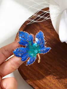 Makroansicht der blauen Emaille- und Strassdetails dieser luxuriösen Ahornblatt-Brosche