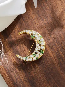 Detailed view of the sparkling moon-shaped brooch with inlaid white rhinestones
