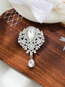 Macro view of vintage silver crystal brooch with large teardrop pendant and rhinestones.