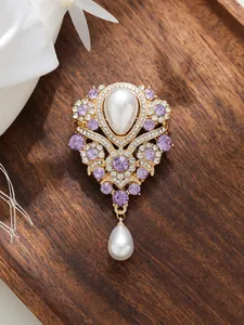 Gros plan détaillé d'une broche vintage violette avec d'élégantes perles en goutte