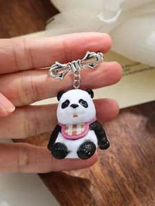 Gedetailleerde weergave van een 3D panda broche van hars met een roze ruitpatroon