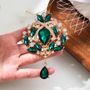 Vintage emerald green crystal brooch with gold alloy and sparkling rhinestones