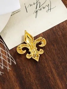 Detailed back view of gold fleur-de-lis brooch showing the secure pin clasp mechanism