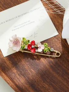 Dettaglio di elegante spilla floreale in smalto con petali colorati e cristalli
