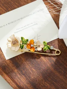 Primo piano di elegante spilla a tulipano in smalto con strass su spilla di sicurezza dorata
