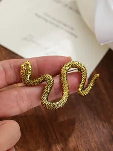 Primer plano de un broche de serpiente dorado detallado con textura de escamas