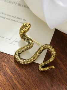 Vista detallada de un broche de serpiente dorada con texturas de escamas finas