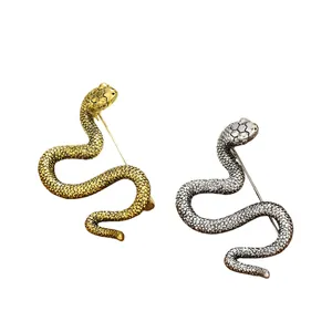 Elegantes broches con forma de serpiente dorados y plateados con textura de escamas detallada
