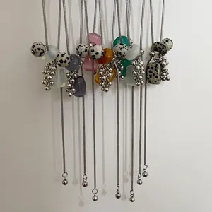 Long pull necklace with dalmatian stone grape clusters and colorful natural stones.