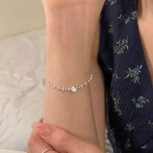 Détail d'un bracelet minimaliste en argent avec une perle ronde brossée sur un poignet