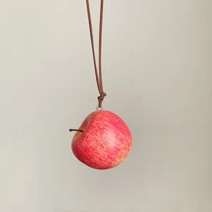 Colgante de manzana roja realista colgado de un cordón marrón minimalista