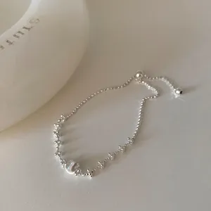 Détail d'un bracelet ajustable en argent minimaliste avec une sphère brossée