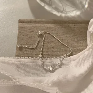 Détail en gros plan d'un bracelet à cordon en argent avec une boule centrale brossée