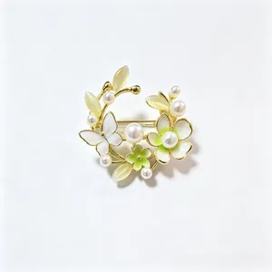 Detailopname van de bloemenkrans broche met parels en vlinders van glanzend emaille