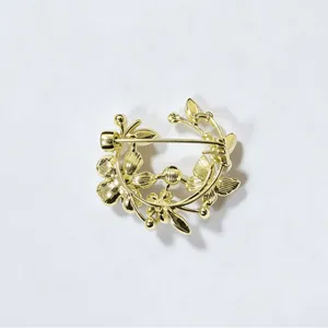 Elegante gouden bloemenkrans broche met een gedetailleerd ontwerp van bloem en blad