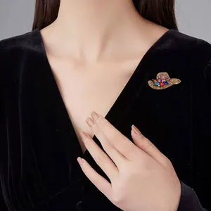 Model wearing a vintage hat-shaped brooch with colorful rhinestones on black velvet
