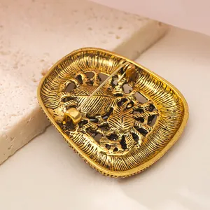 Close-up detail of a vintage gold brooch back featuring an intricate safety pin clasp.